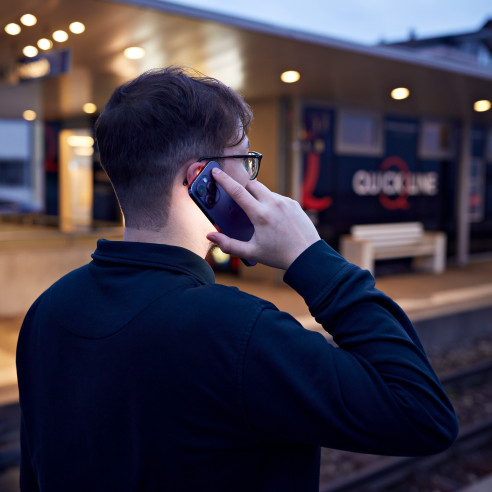 Mann telefoniert am Bahnhof Reinach AG